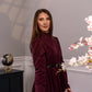 Woman wearing a long sleeve modest maxi dress in burgundy for graduation or special occasions, with puff sleeves and elegant cotton-blend fabric.