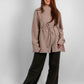 Woman wearing a long sleeve asymmetrical blouse in luxurious premium fabric, tunic length, modest fashion style.