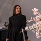 Woman wearing a long sleeve modest maxi dress in black for graduation or special occasions, with puff sleeves and elegant cotton-blend fabric.